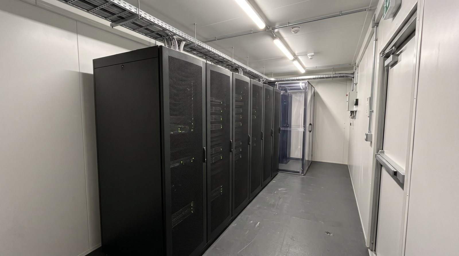 Concept visualisation: inside the module, a single row of enclosed equipment cabinets beside the cold aisle